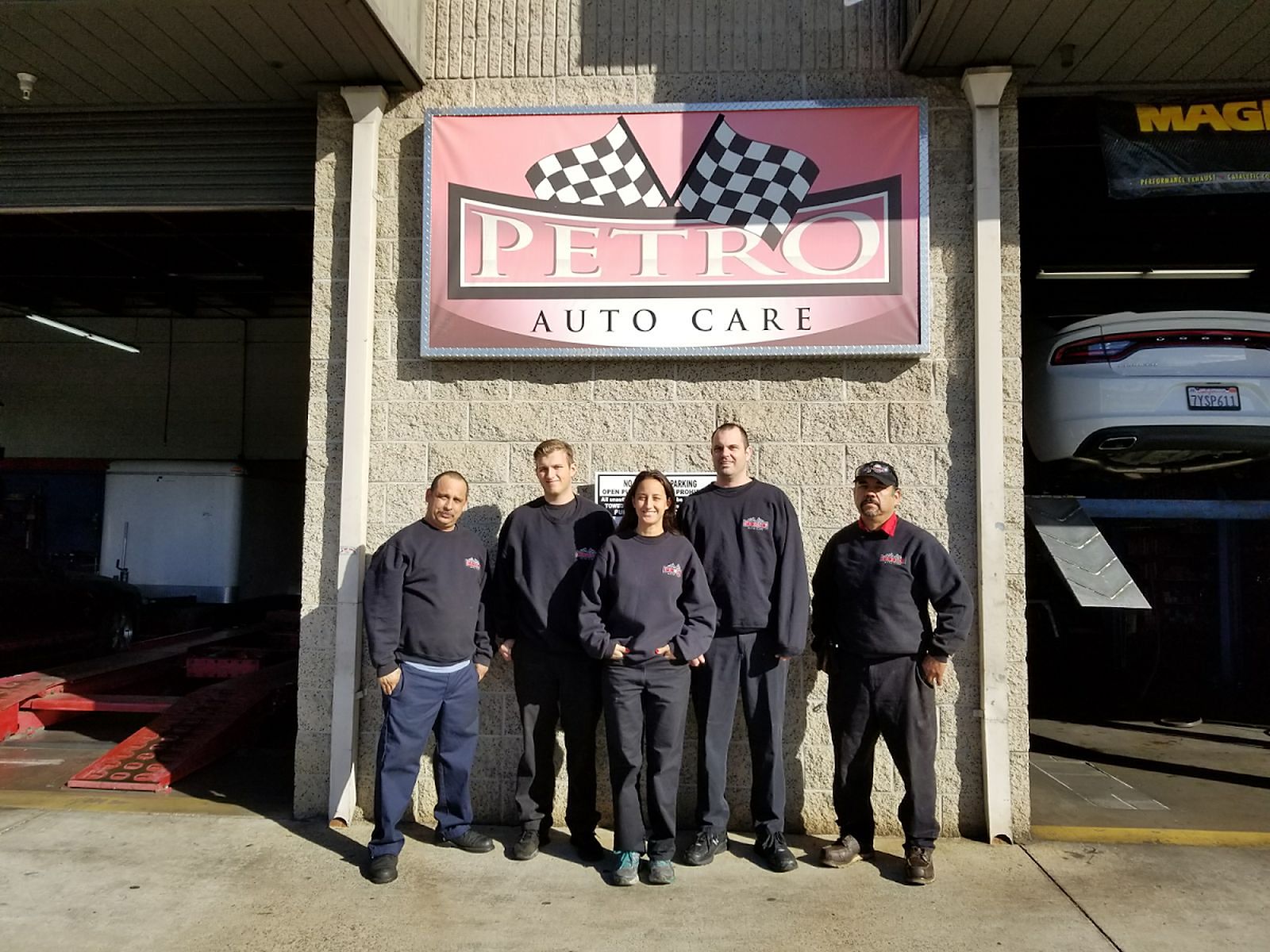 The Petro Auto Care team standing in front of the shop sign